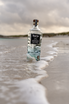 Bottle of Baria on a beach with waves
